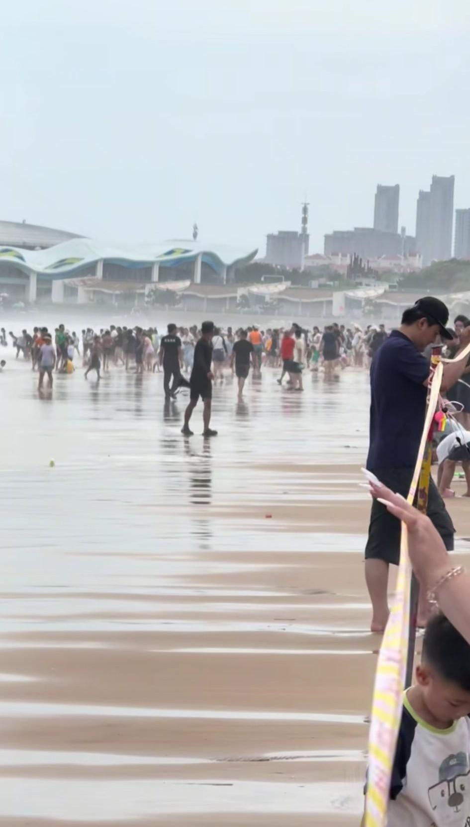 8月9日，山东青岛，海边浴场风浪太大已拉起警戒线，游客还是不听劝冲出！保安无奈表