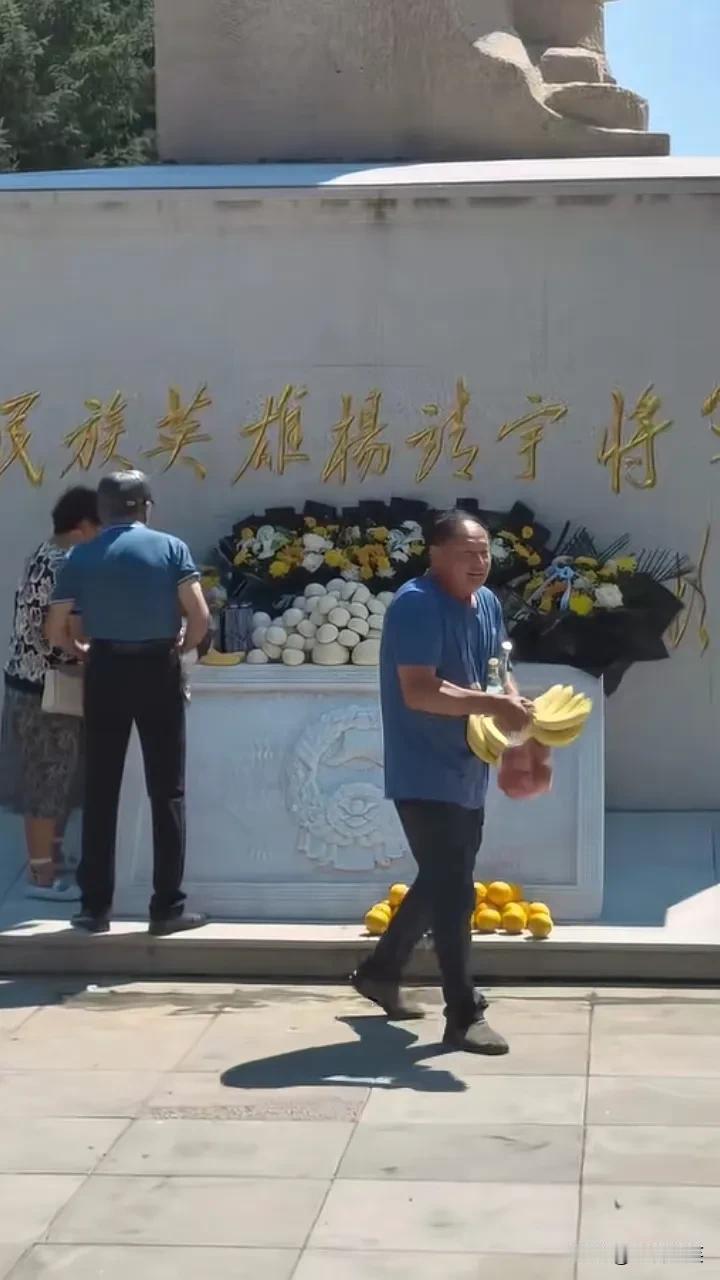 3个中老年人拿走了杨靖宇将军的贡品，大妈装了一大包馒头，另外两名男子拿了香蕉、橙