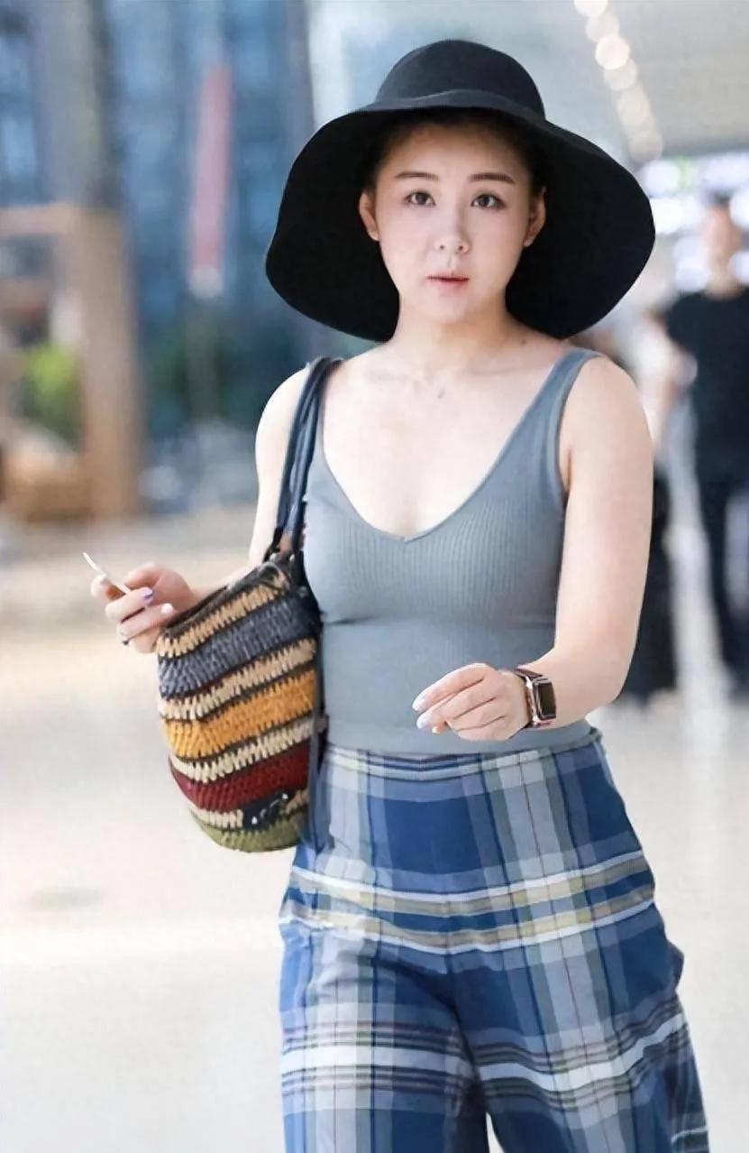 李小萌机场私服太有味道了！灰色针织背心搭配蓝格阔腿长裤，简约随性。修身背心勾