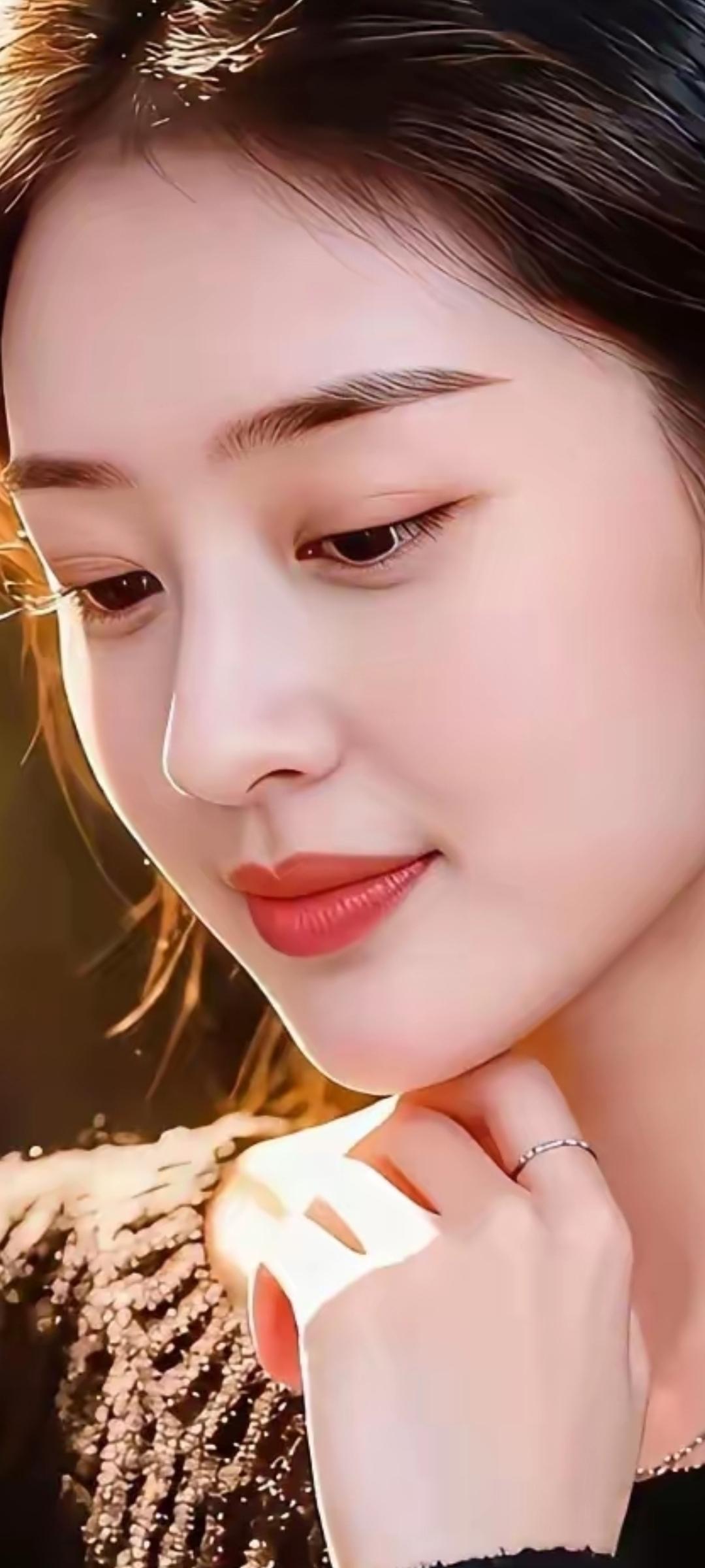 温柔的光线下，她轻轻抚摸着自己的颈链，散发着优雅的气息。