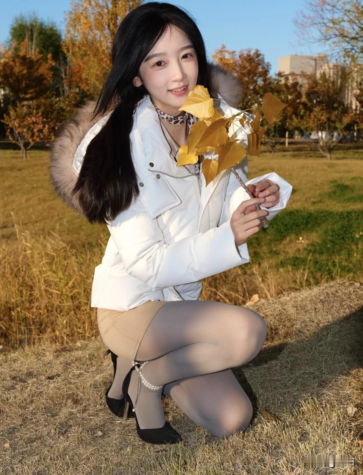 秋日暖阳下的优雅穿搭，浅米色衬衫搭配卡其色短裙，脚踩黑色高跟鞋，尽显时尚与优雅。