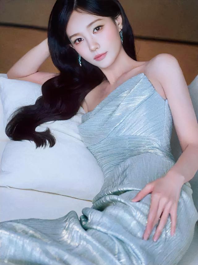 浅蓝裙裾铺开，像月光落在海。长发垂在白枕边，耳坠摇着静下来。她倚