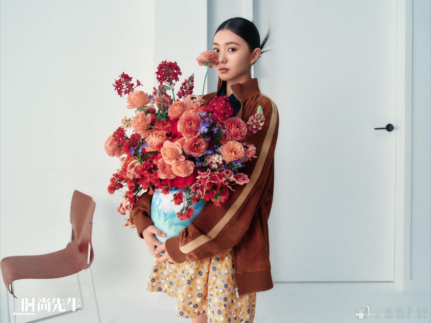 刘浩存捧花而立时，花影在肩头写诗，裙摆扬起春的韵脚。俯身轻嗅间，芬芳漫过时光褶皱