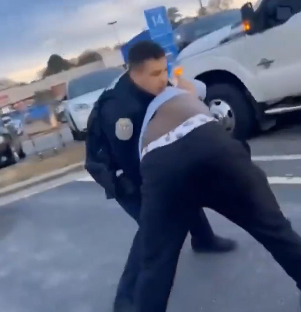 美国街头的日常。在美国某地的沃尔玛超市停车场，一名警察跟一名黑人发生了肢体冲