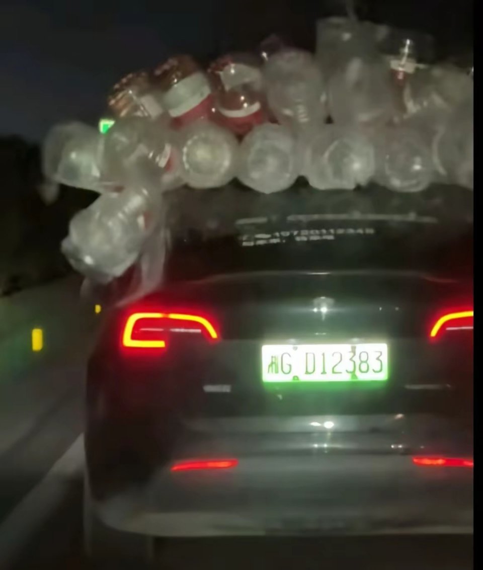 怪事！春节返程的高速路上，一辆特斯拉的车顶上，绑着几十个空矿泉水瓶。真让人纳闷，