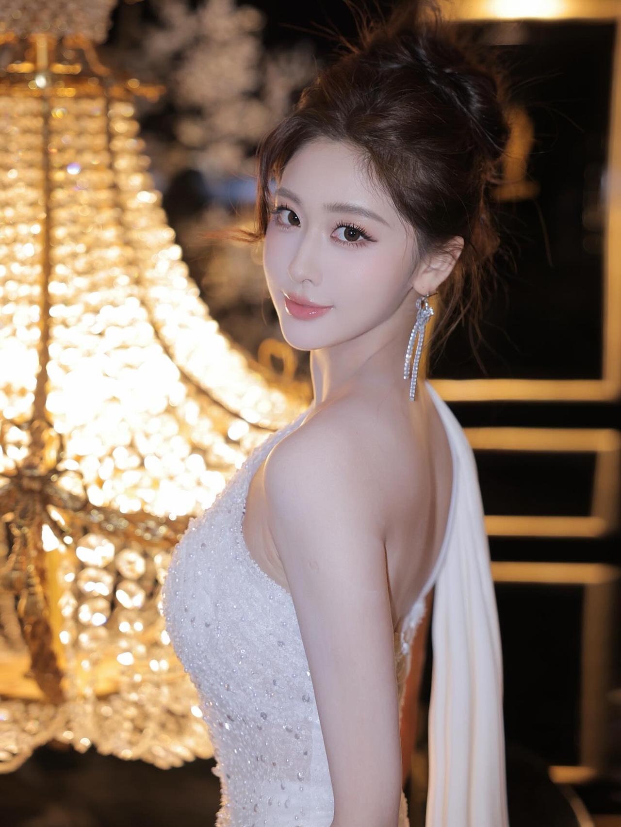 梦幻灯光下的优雅美人，闪耀的礼服与精致妆容相得益彰。优雅自信穿搭分享分享街拍图