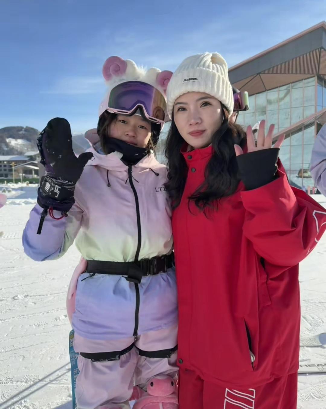 11月27日，全红婵在新疆滑雪场与漂亮女粉丝合影了，脸冻的通红，戴着黑色手套朝着