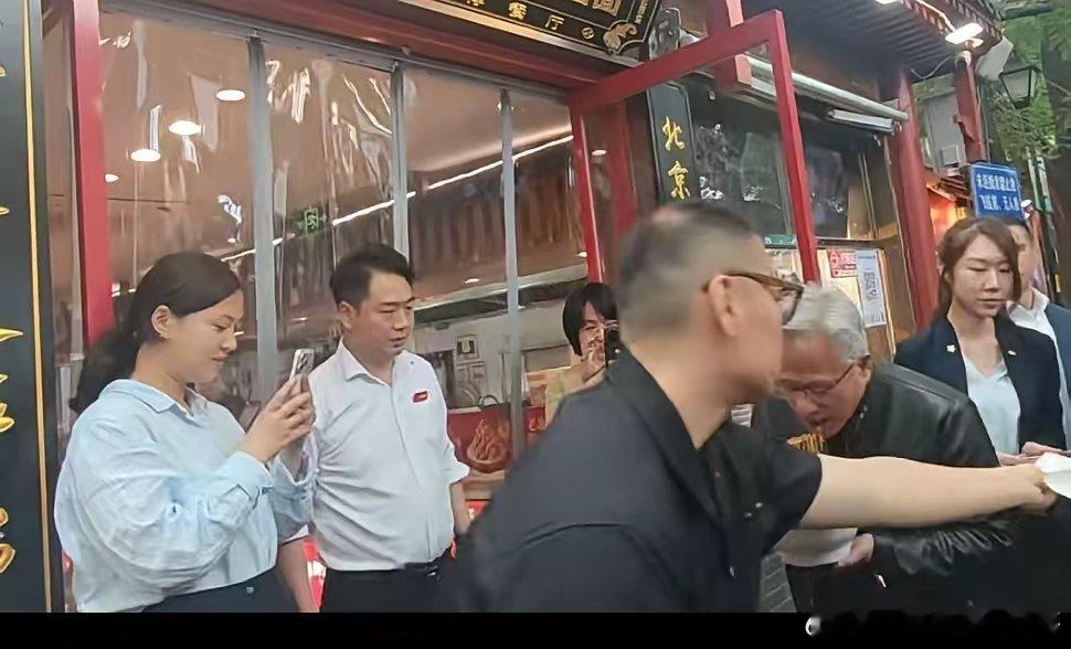 黄仁勋去吃炸酱面！大热天穿皮衣，站在门口大口吃面条，高盛CEO也在。黄仁勋以爱
