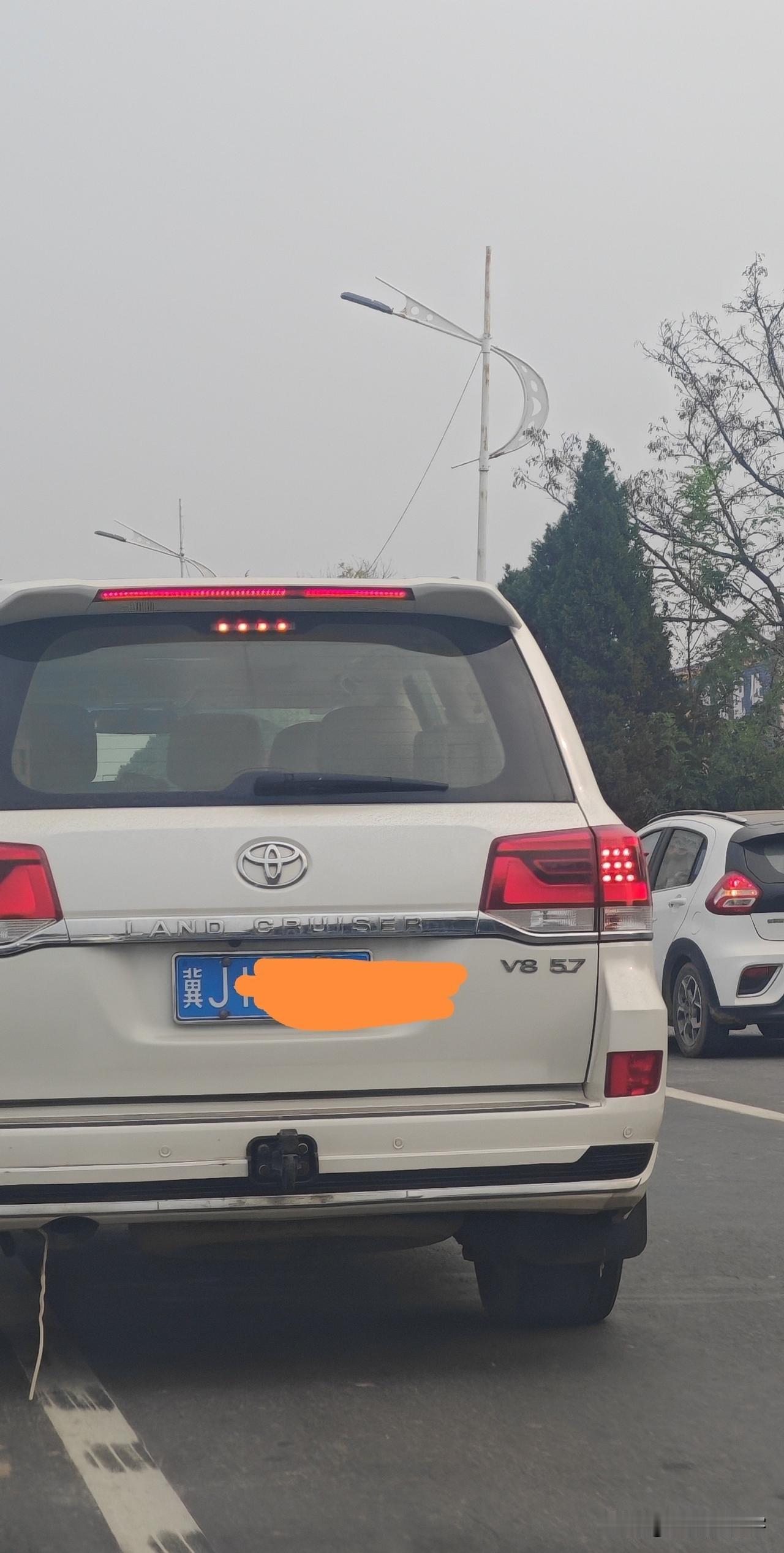 在路上偶遇一台兰德酷路泽，很多人也喜欢叫它陆地巡洋舰。看到车尾这个V85.7的