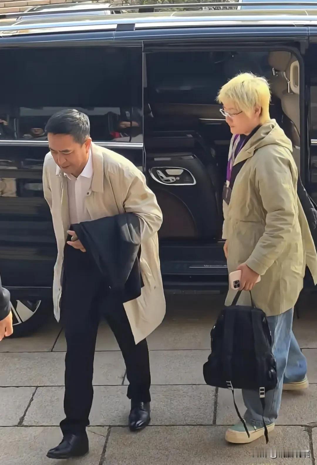 久未现身的演技派张嘉益出席活动，穿着长外套黑裤子，头发花白，身形弯腰驼背，完全直