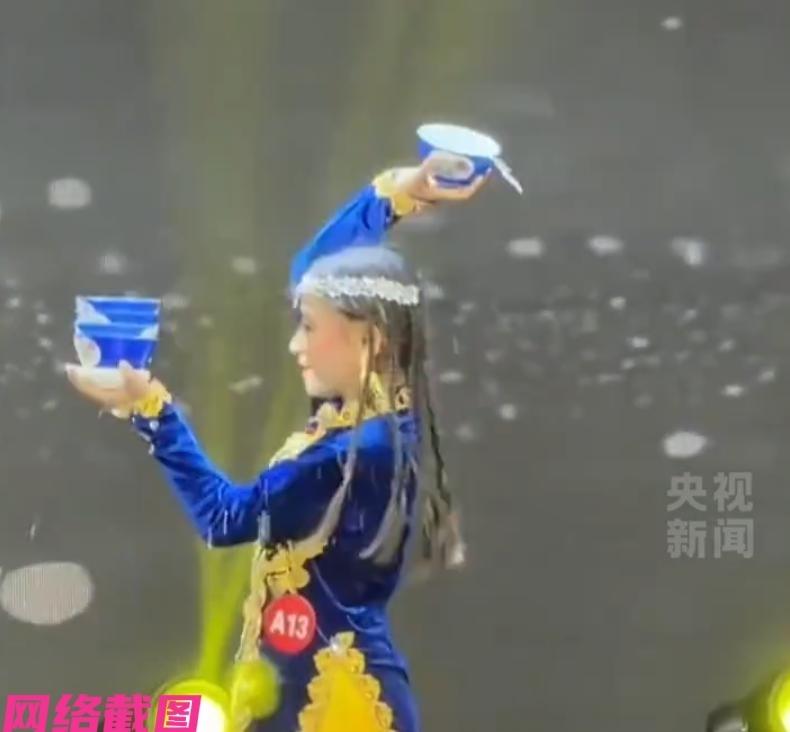新疆有个小女孩在比赛途中，表演顶碗舞的时候发生失误，头顶的几个碗被摔落打碎，看到