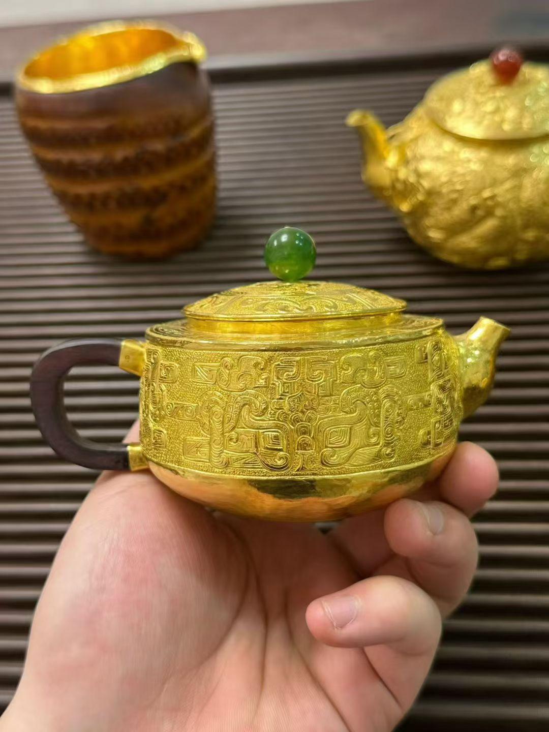 真心话茶局手工錾刻的足金茶壶，复刻着商周青铜的饕餮纹样，在黄金上流转出千年古韵。