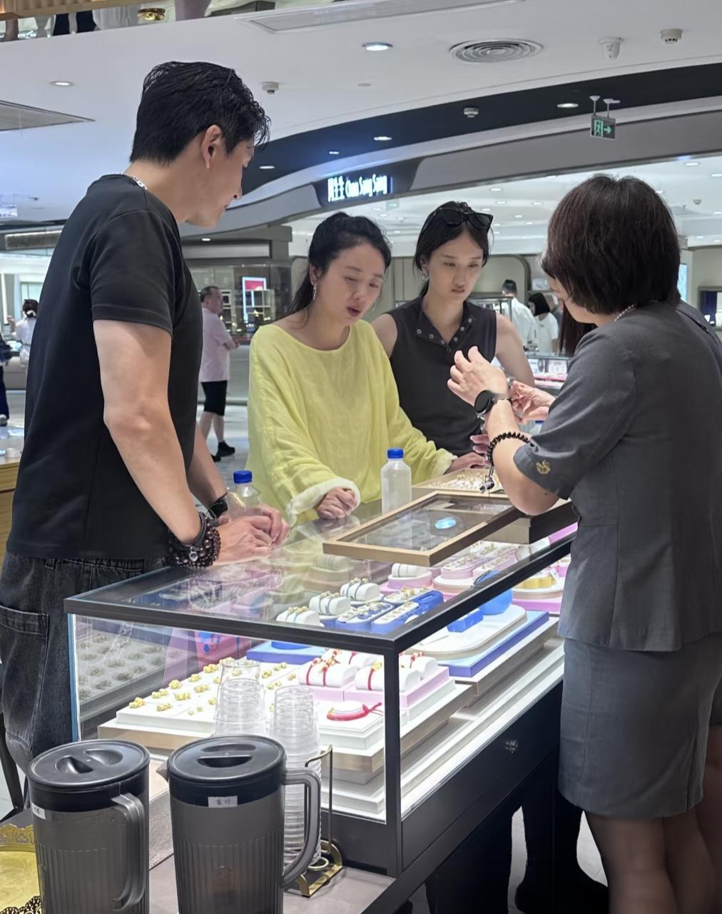 48岁小李琳和老公经超带着大女儿现身一间大型商场买黄金首饰，她穿着一身朴素的休闲