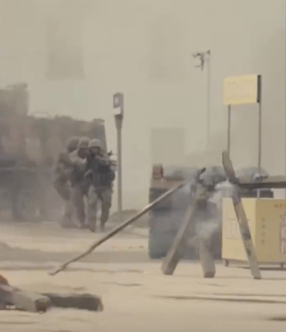 解放军巷战演习旁边小吃摊亮了。日前，解放军在进行巷战演习时，背景中一处小吃摊招