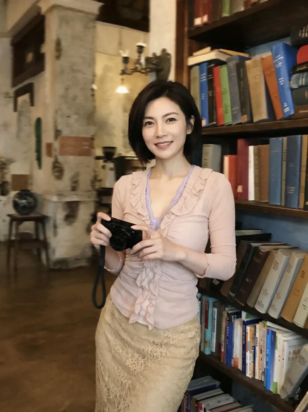 一个女人在书店拍照，笑得很开心。