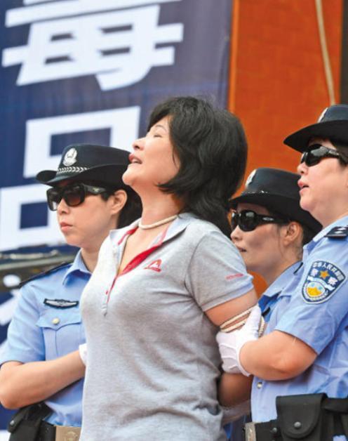 2015年，广东，一个女人被五花大绑押赴刑场，身后站着几位女警，她叫胡巧贤，42