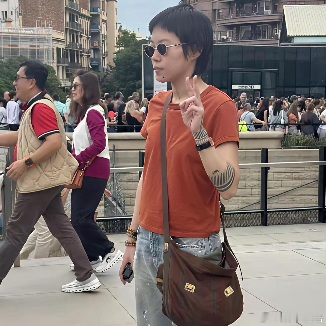 窦靖童在西班牙溜达，寸头配5串珠子超有个性，模样和一举一动都超像王菲。28岁单身