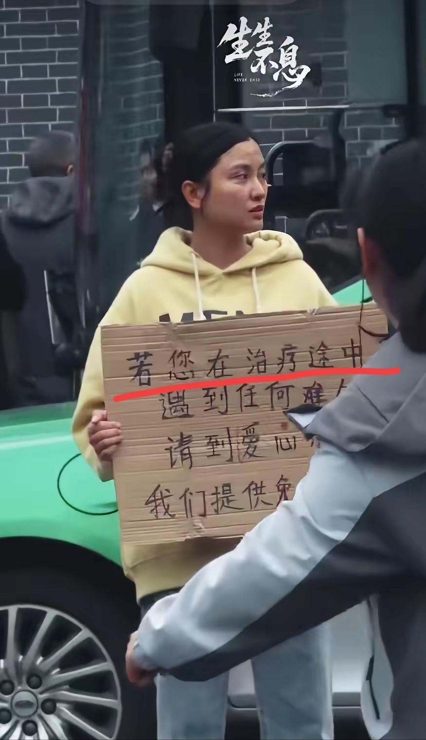 四川成都，华西医院门口有一个女孩子胸前举着一块牌子，写着提供免费住宿吃饭，很多人