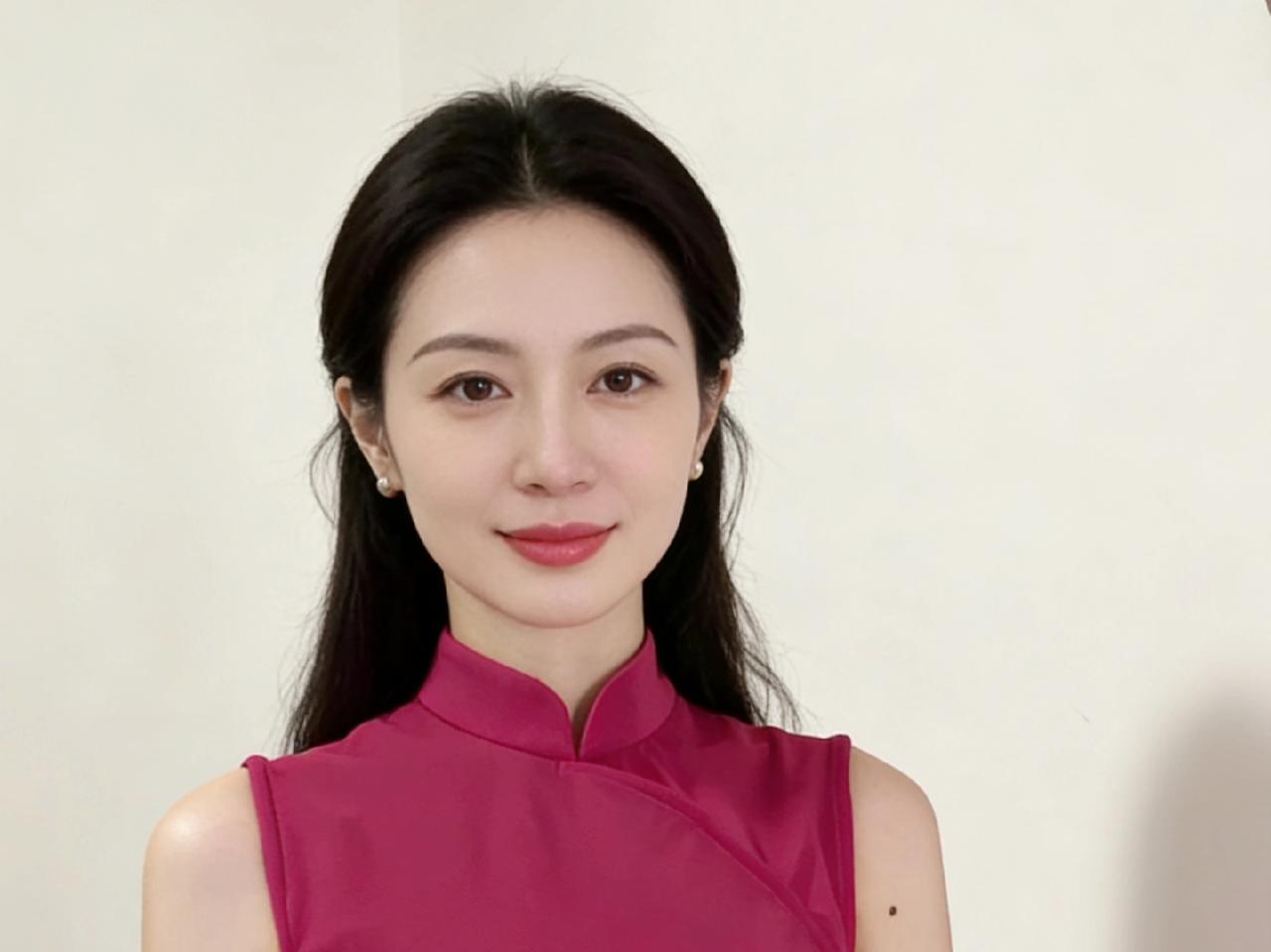 一袭玫红旗袍，裁去了俗世的庸常立领斜襟挑起东方的韵，无袖的设计让肩颈的线条，