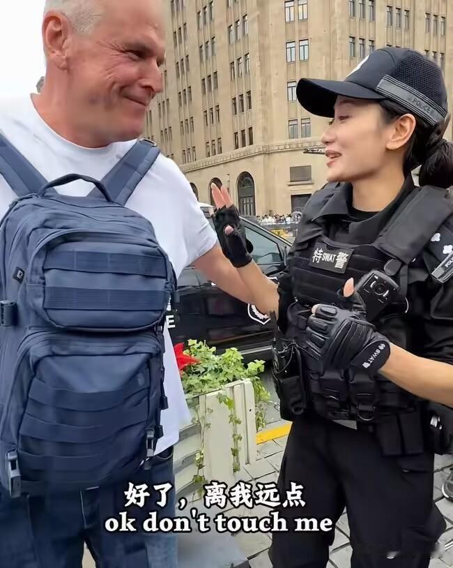 国庆外滩，一个老外想搭执勤女特警的肩膀合影，姑娘笑着把手一拨。有网友归纳："So