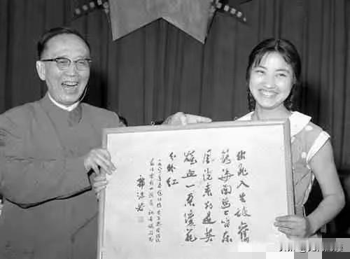 郭沫若先生亲笔书写了这幅书法作品，并亲手赠送给这个女子，两个人还合影留念，照片中