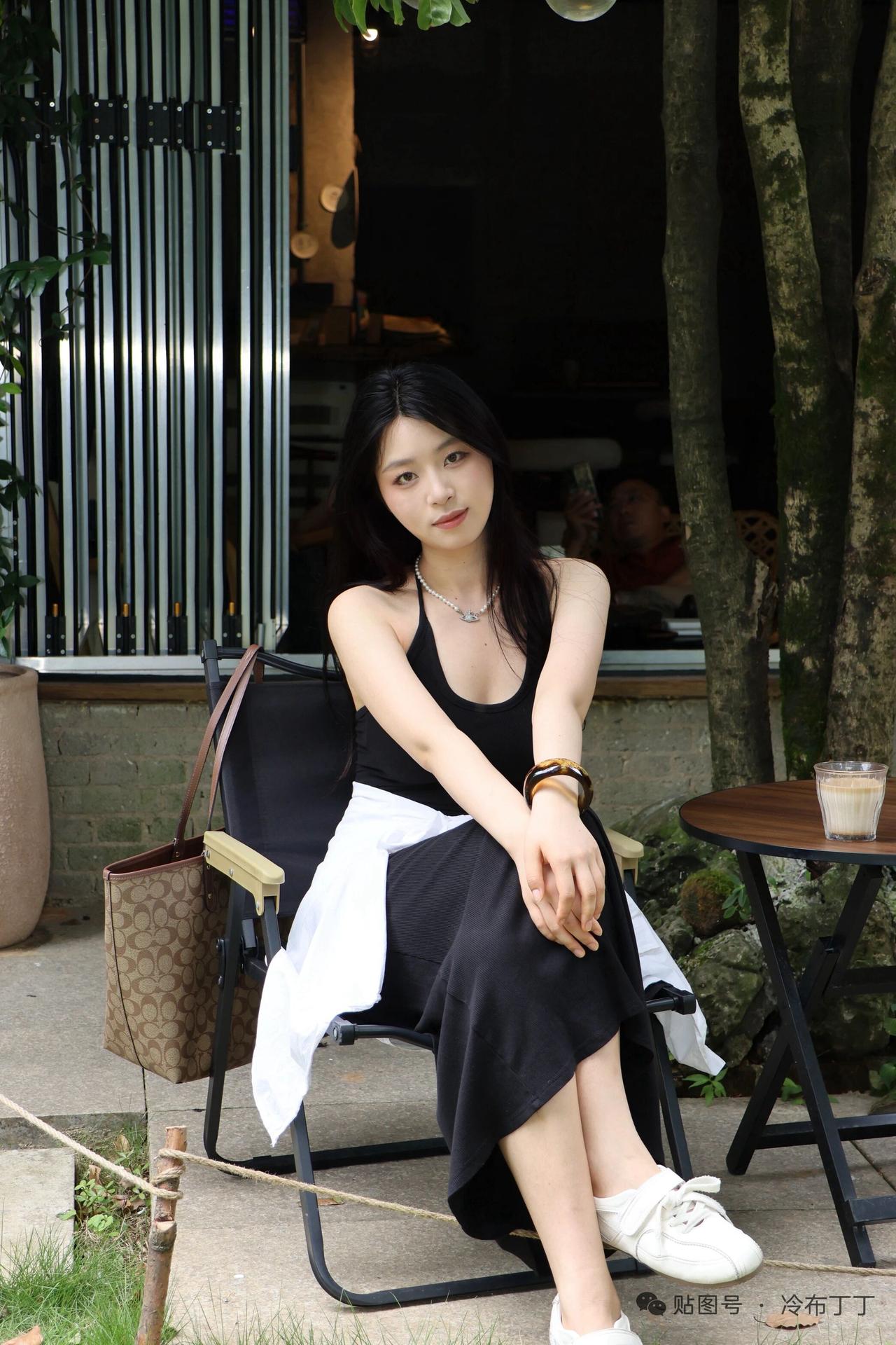 一个女孩坐在户外咖啡馆里。