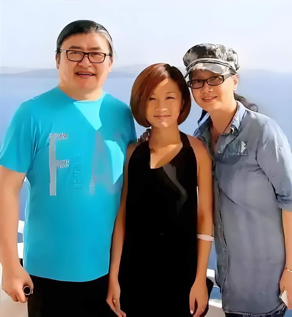 刘欢一家三口幸福满满的全家福刘欢身穿天蓝色T恤，下身搭配黑色裤子，戴着眼镜，