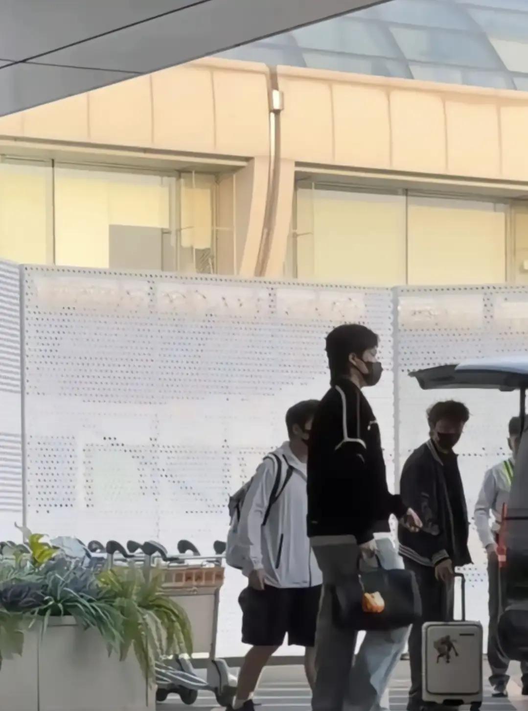 大头拖着箱子落地北京，草莓熊把书包挂在自己脖子上跟在后头，CC推着俩行李箱走旁边