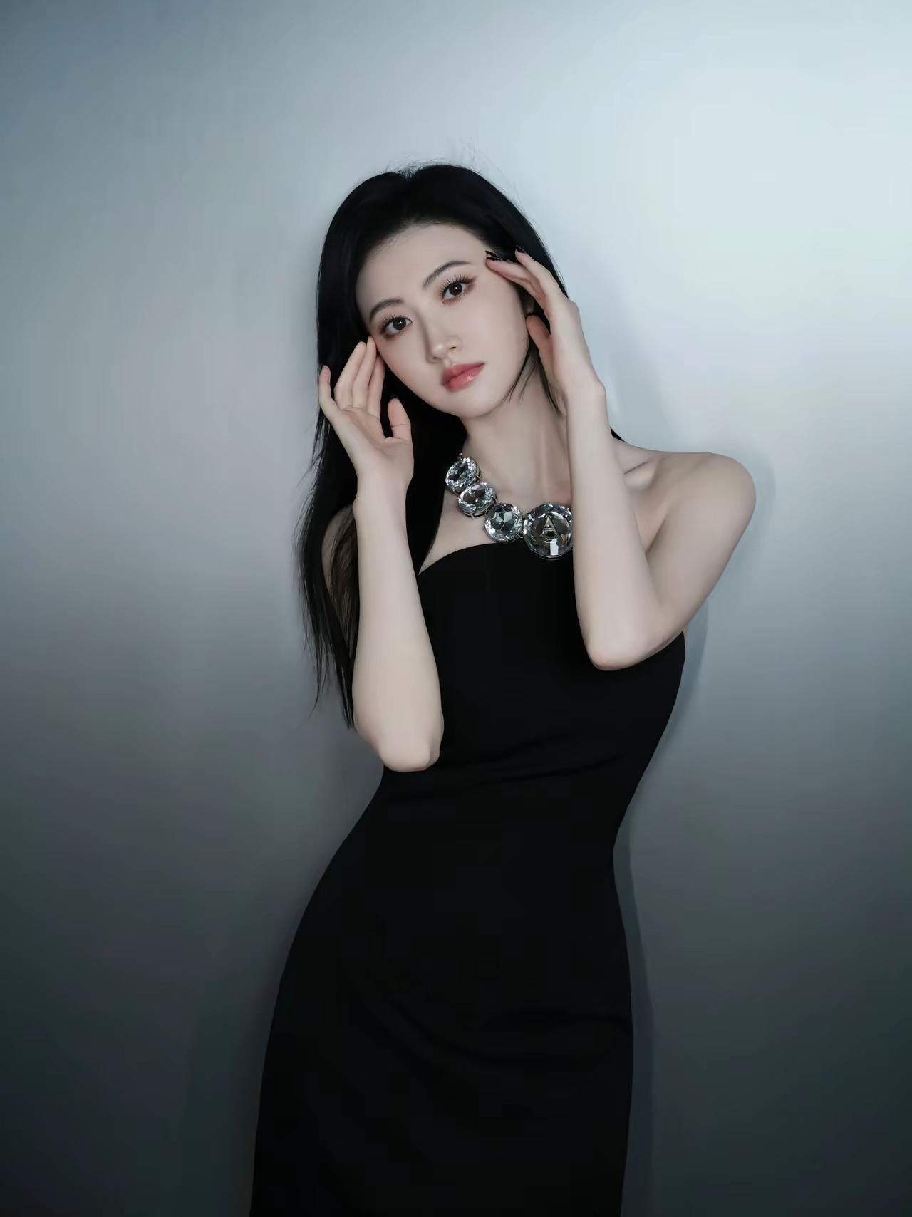 黑衣美人倚，银饰映芳颜。