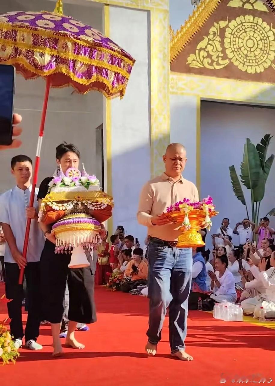 10月27日,吴镇宇带着儿子费曼在西双版纳参加供养仪式,吴镇宇手捧贡品神情严肃又