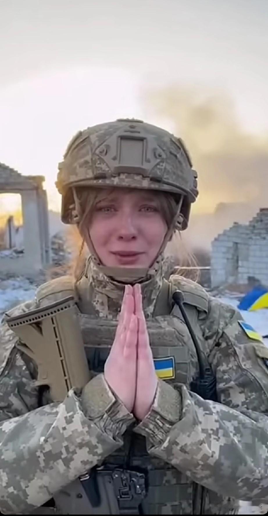 这个乌克兰女子，身上全副武装，双手合十对着镜头，眼中噙满了泪水，嘴里不停的说着话