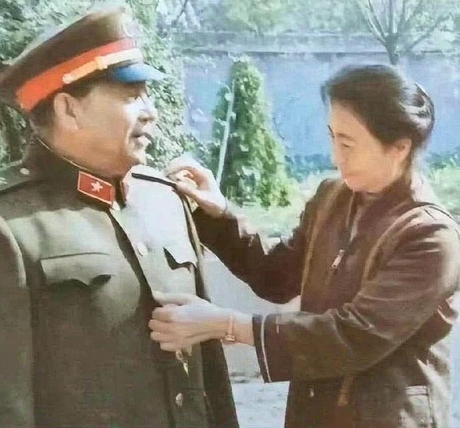 1985年，全军换发85式新式军服，庭院之中，唐贤美正细心为丈夫秦基伟整理军装肩