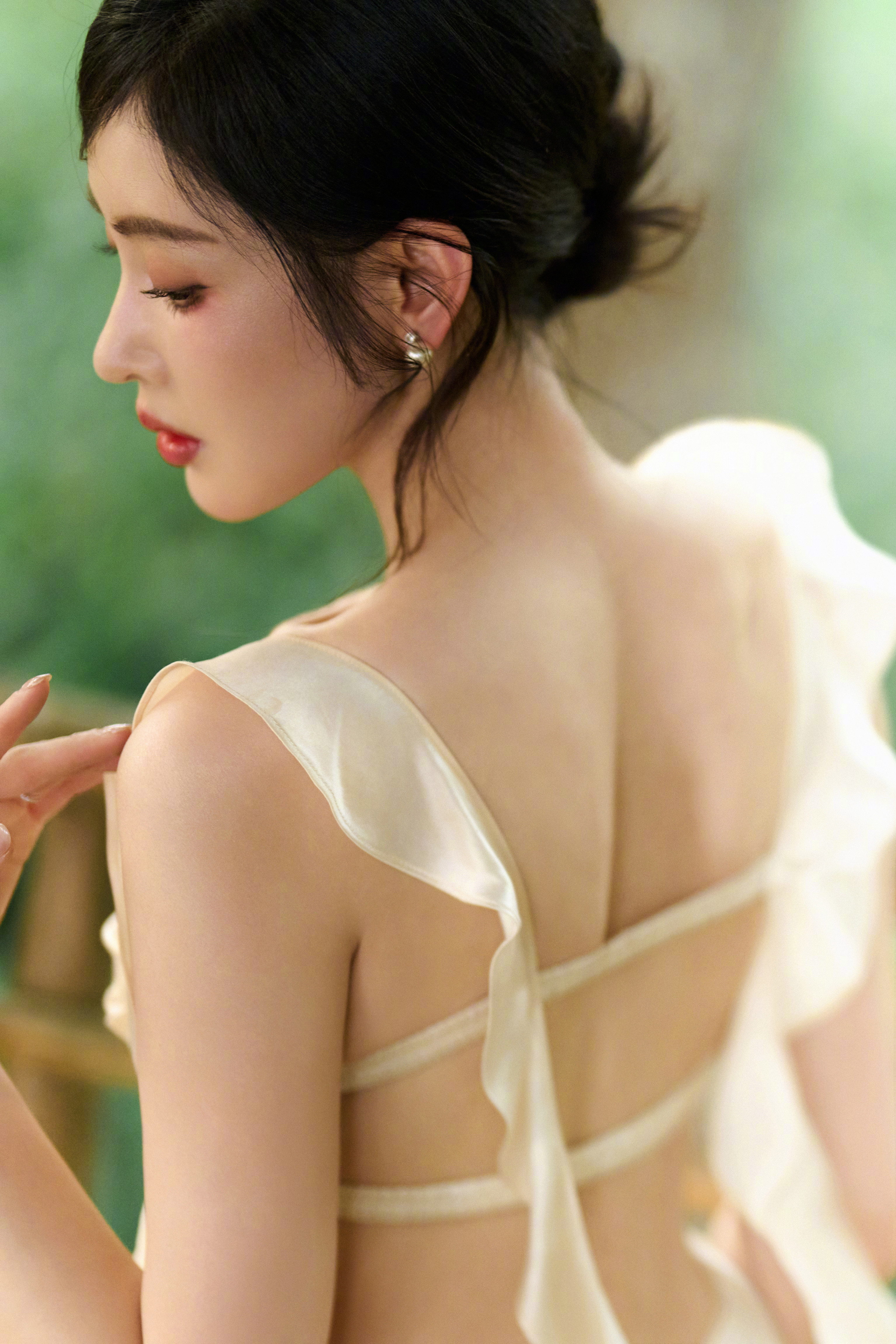 张天爱浅黄长裙勾勒出曼妙身姿，慵懒与优雅并存，她就是这片绿意中最动人的风景。