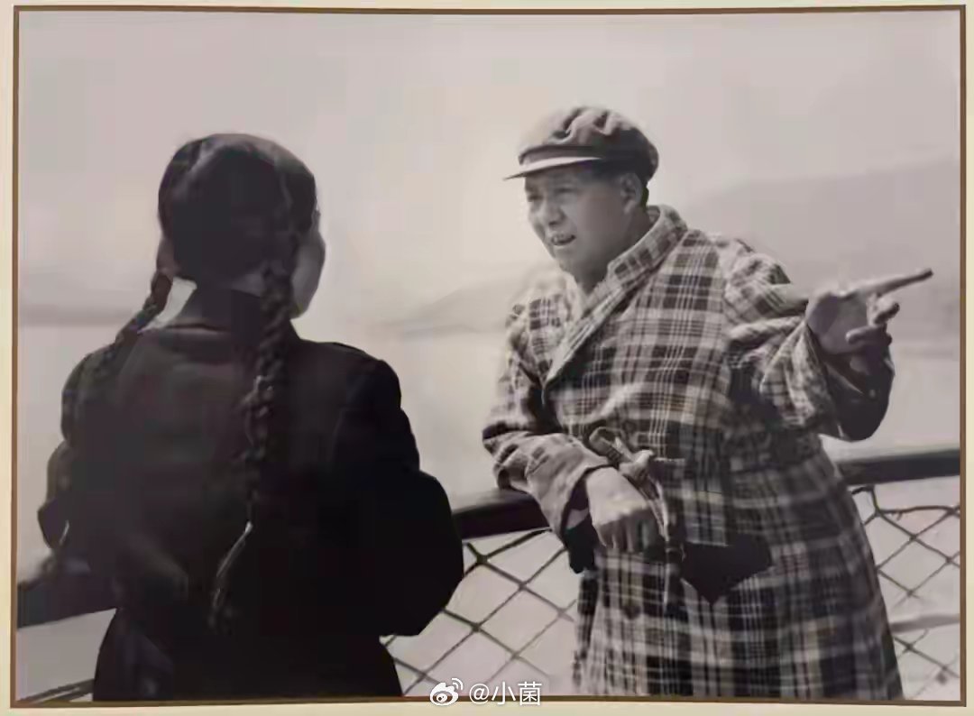 毛主席靠在栏杆边和工作人员说着话，这场景好亲切啊，工作人员也认真的听着，