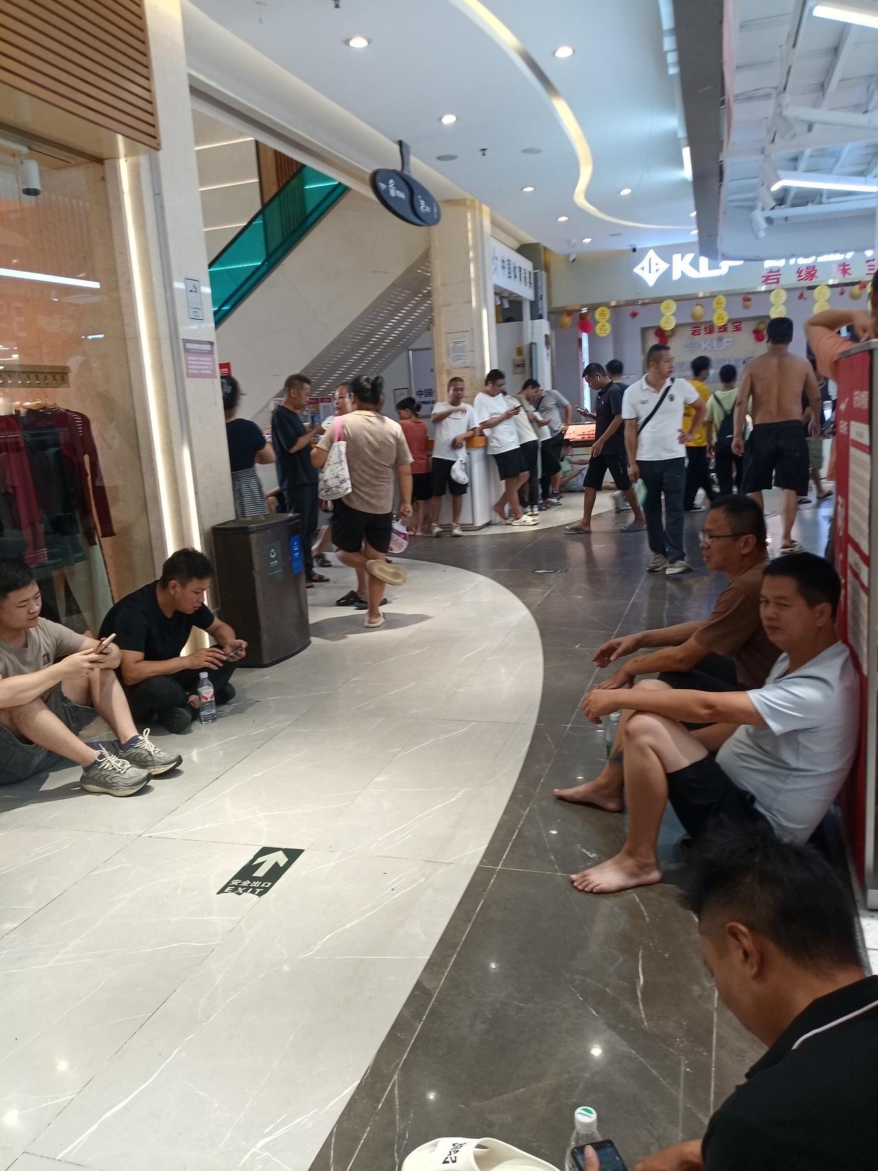 广州海珠区万德信百货楼下，好多人在商场里面蹭免费的空调，广州的天气太热了，比前几