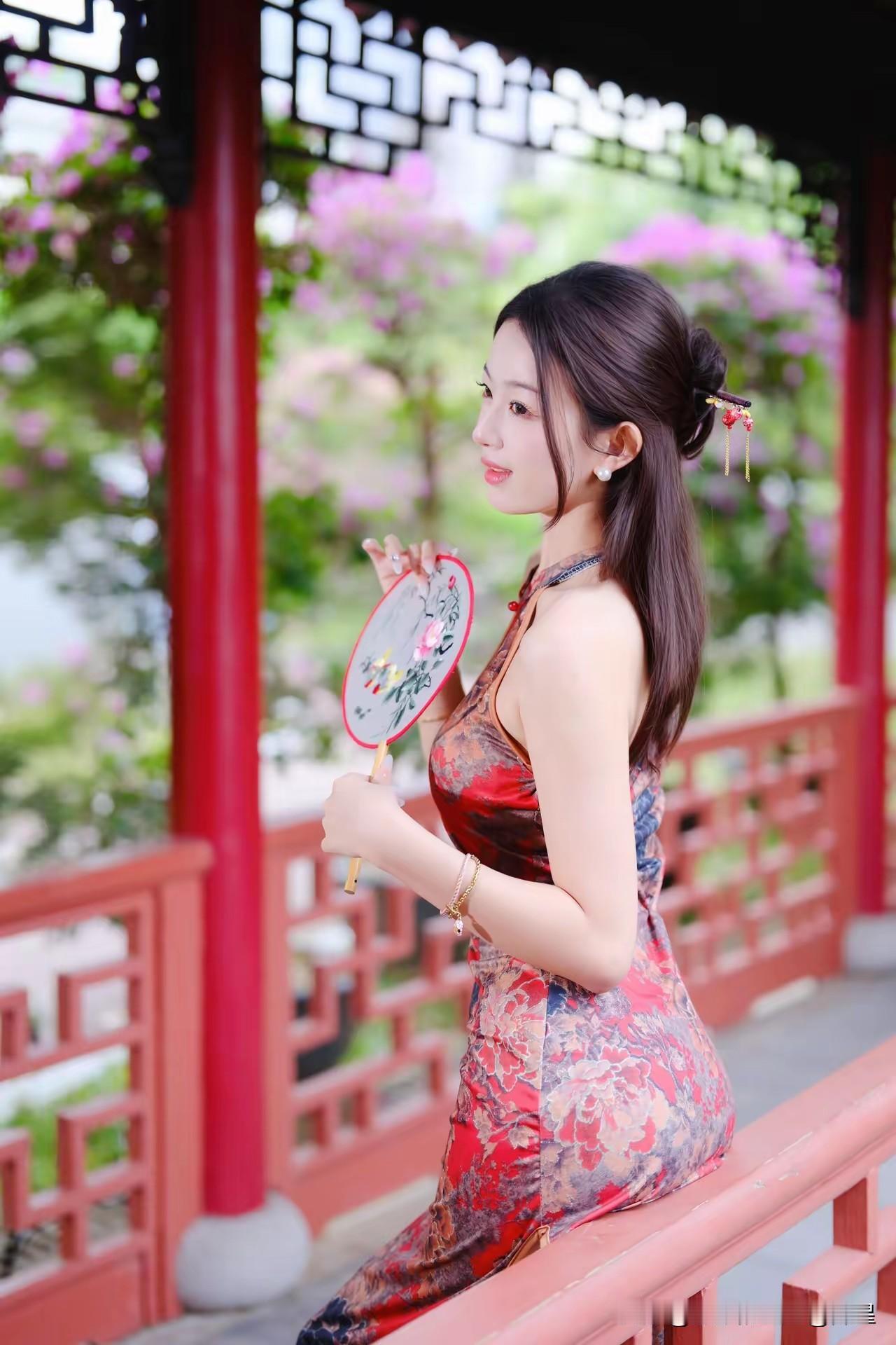 红袖添香夜，花影入画来。她立于花园长廊中，刺绣扇摇曳，更显其娇艳动人，