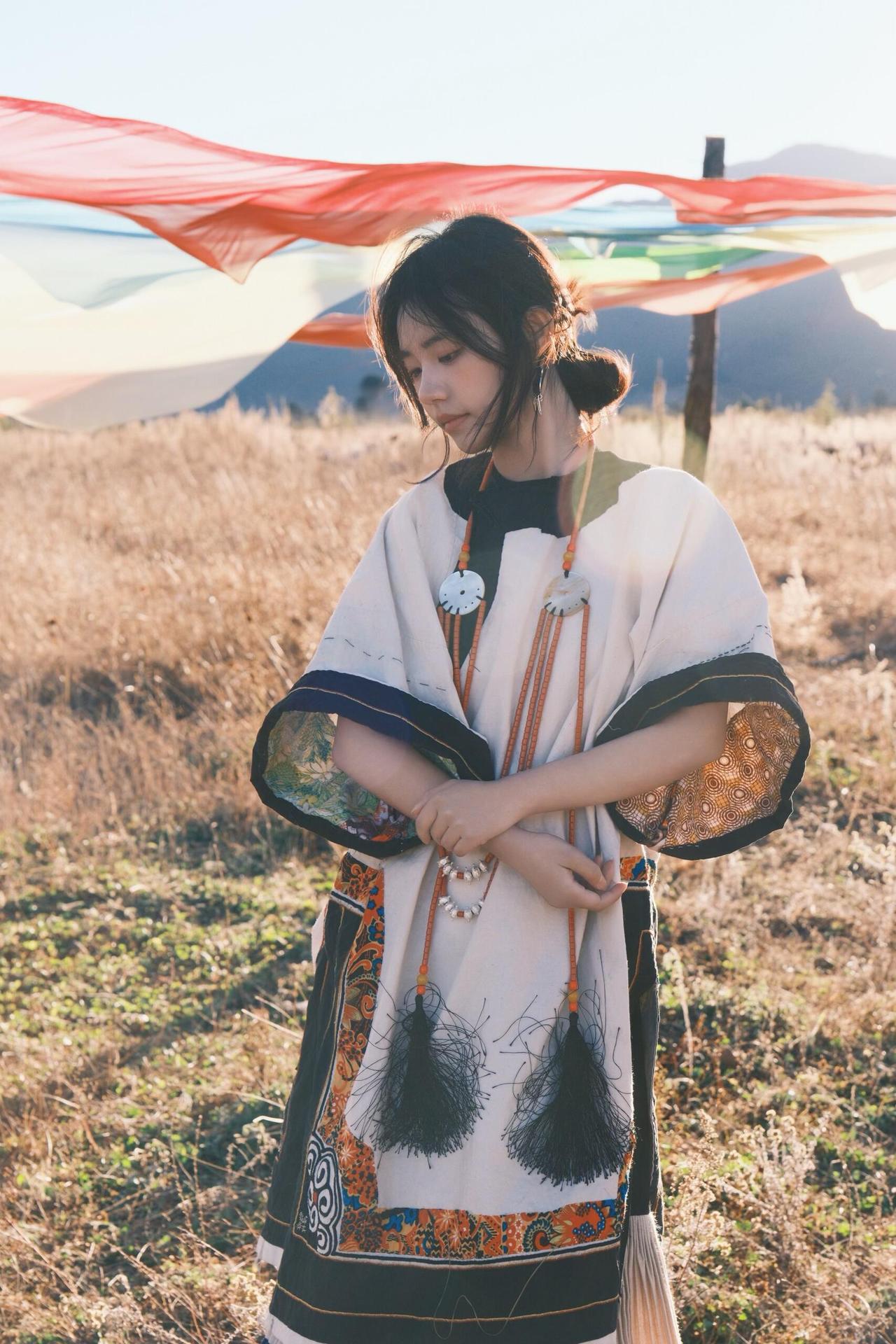 环境人像的魅力，在于用场景和道具撑起画面的叙事性。这次拍摄里，经幡、木亭、湖水都