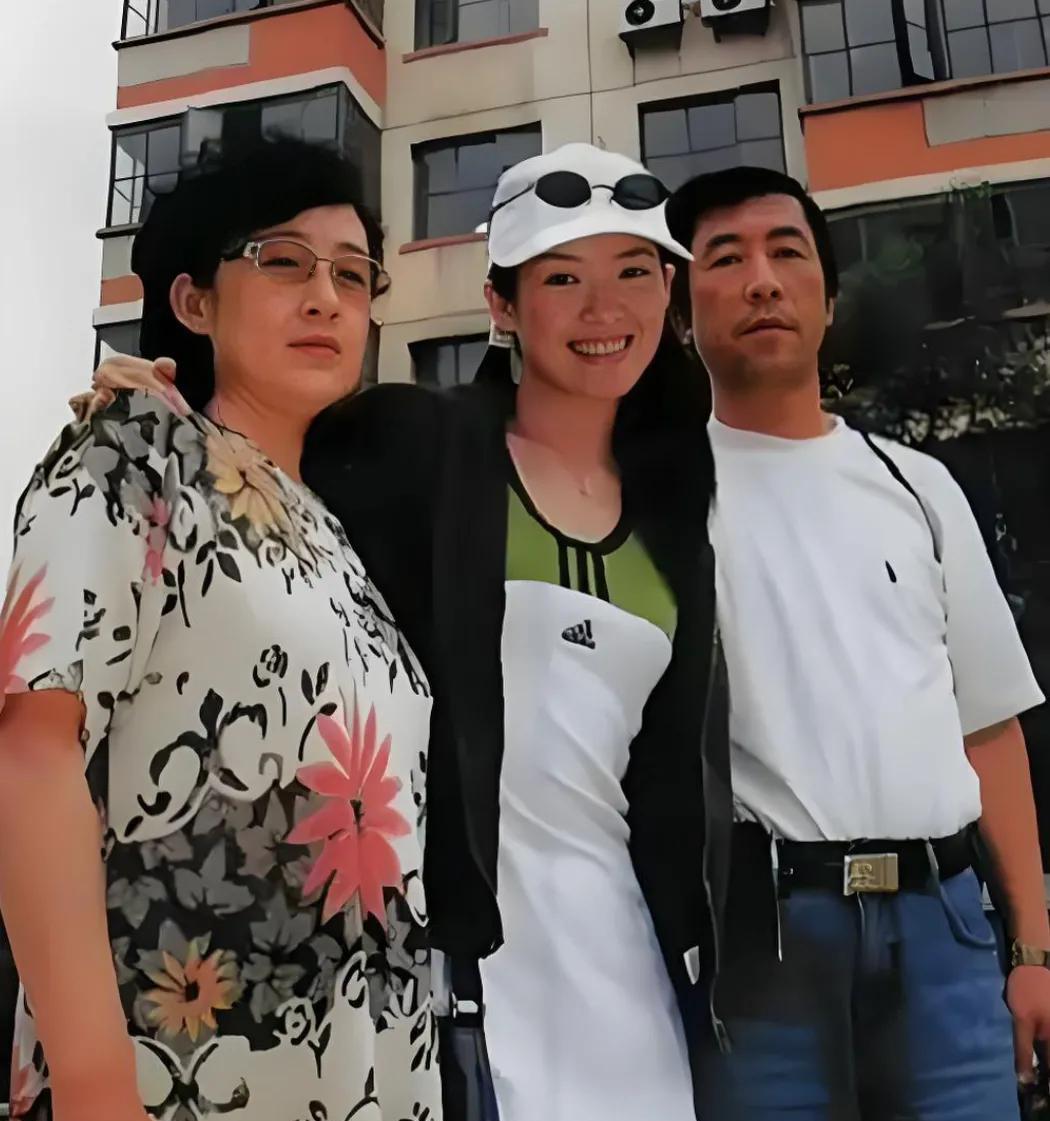 这是章子怡和父母的一张合影照片。少女时代的章子怡打扮的十分青春靓丽，戴着白色时尚