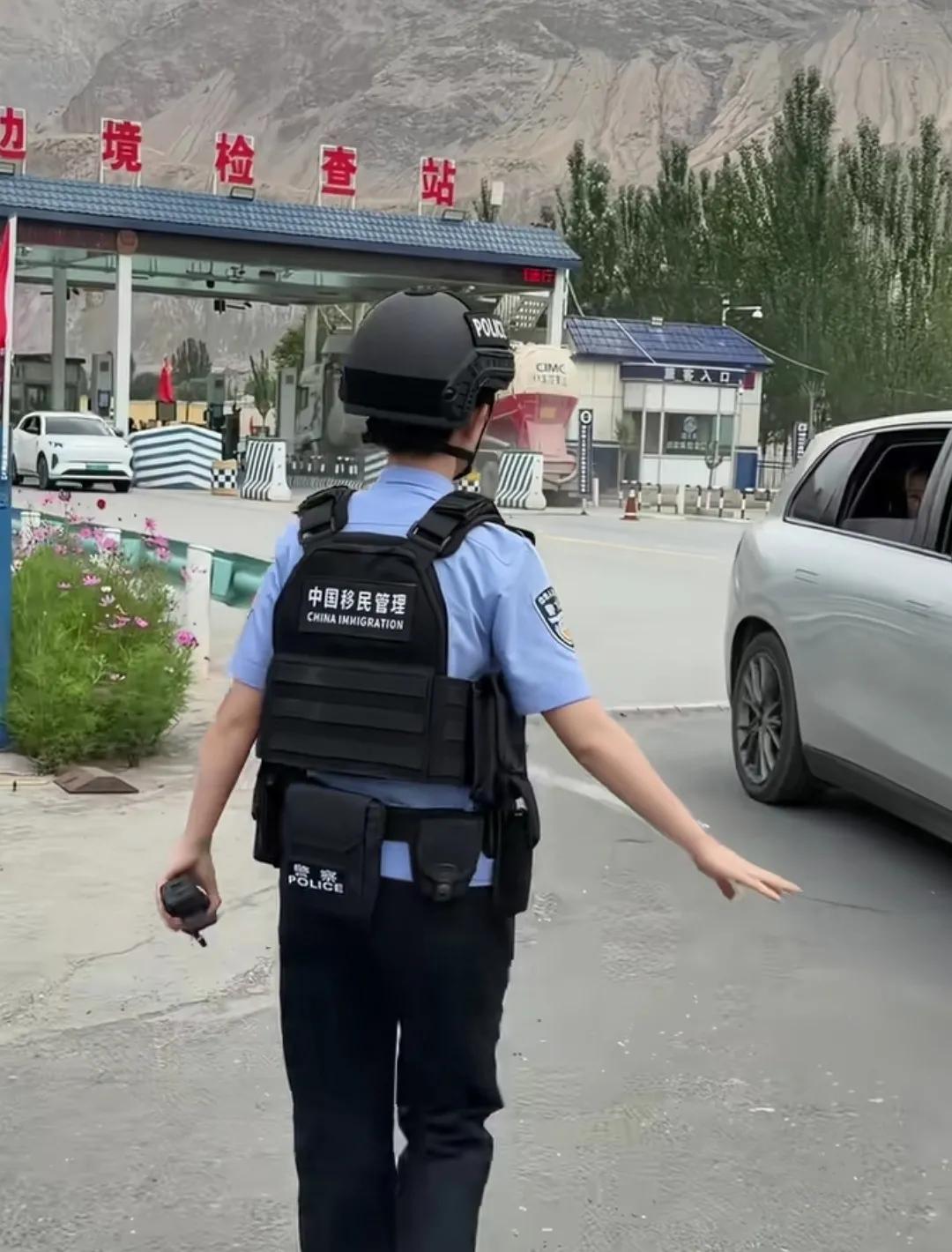 国边境一女警察认真检查车辆及驾乘人员。