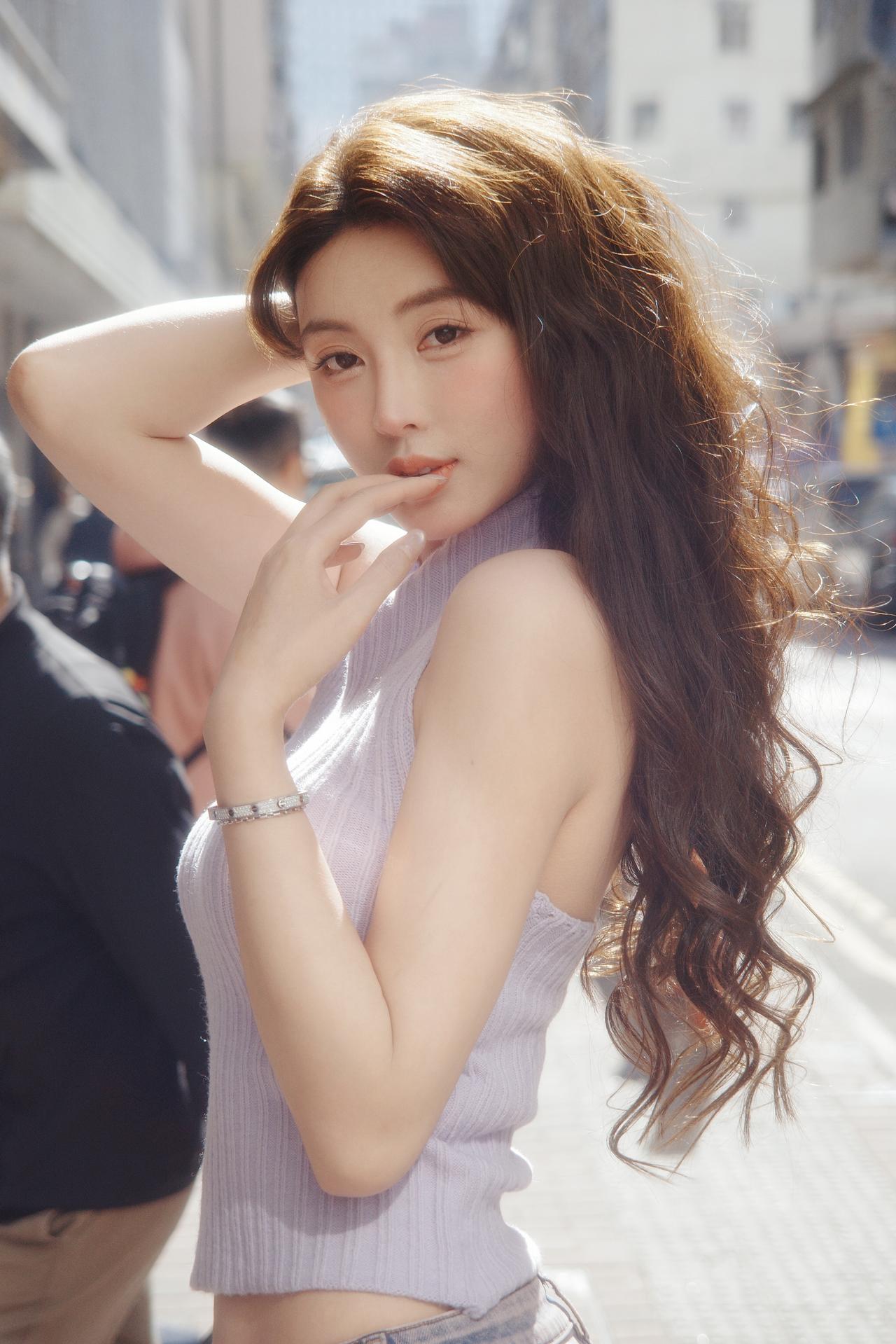 《街隅清韵》浅紫轻衫映日华，柔丝漫卷逐风斜。回眸一笑街光暖，淡扫尘嚣自带