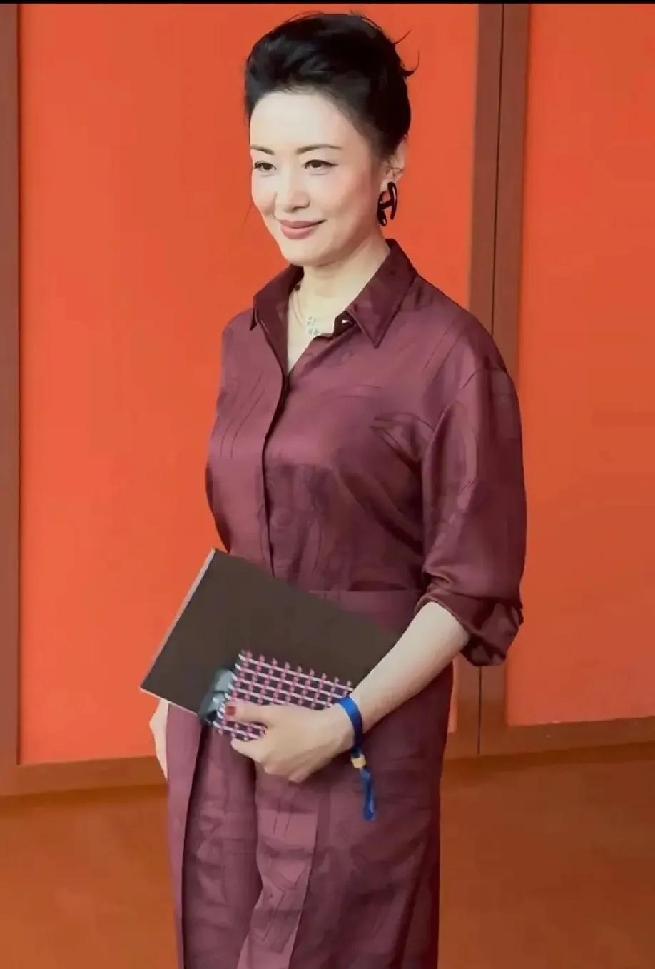 57岁周涛惊艳时尚场！酒红套装勾勒绝美曲线6月13日，57岁的周涛现身时尚