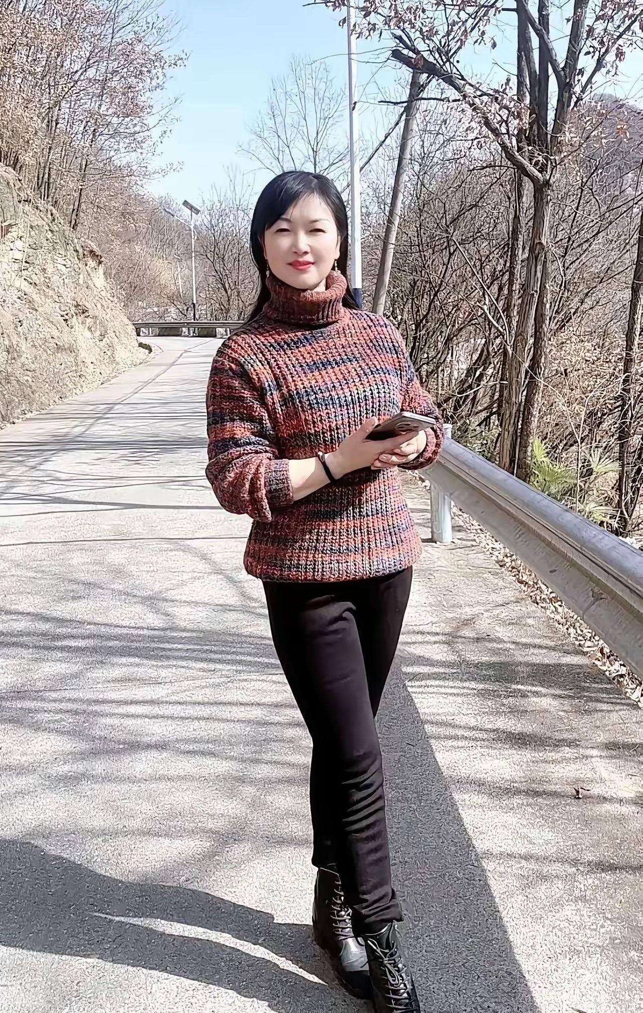 初春的风景阳光在山间小路上铺开柔软的金箔她立于其中彩色毛衣像一团刚从冬