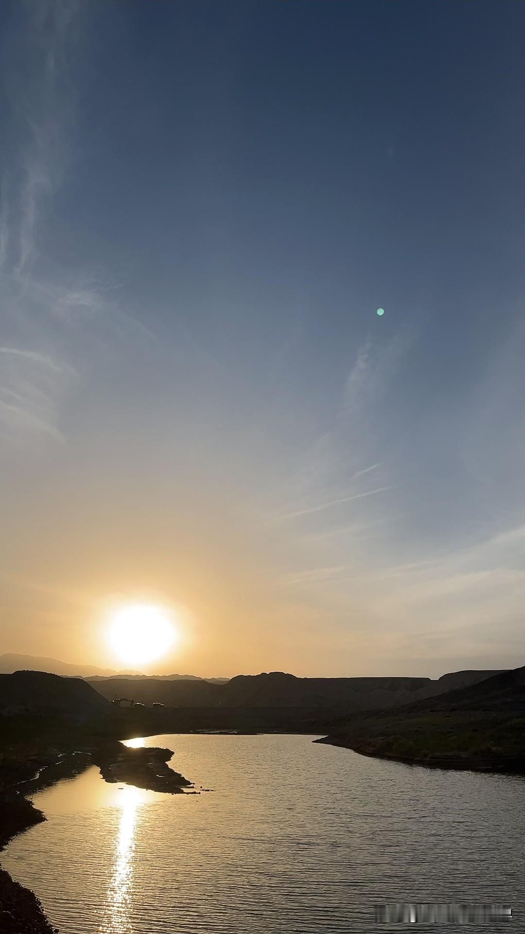 傍晚在荒野里撞见这一汪水湾时，瞬间被勾住了脚步。落日把金箔似的光揉进水面，波光一