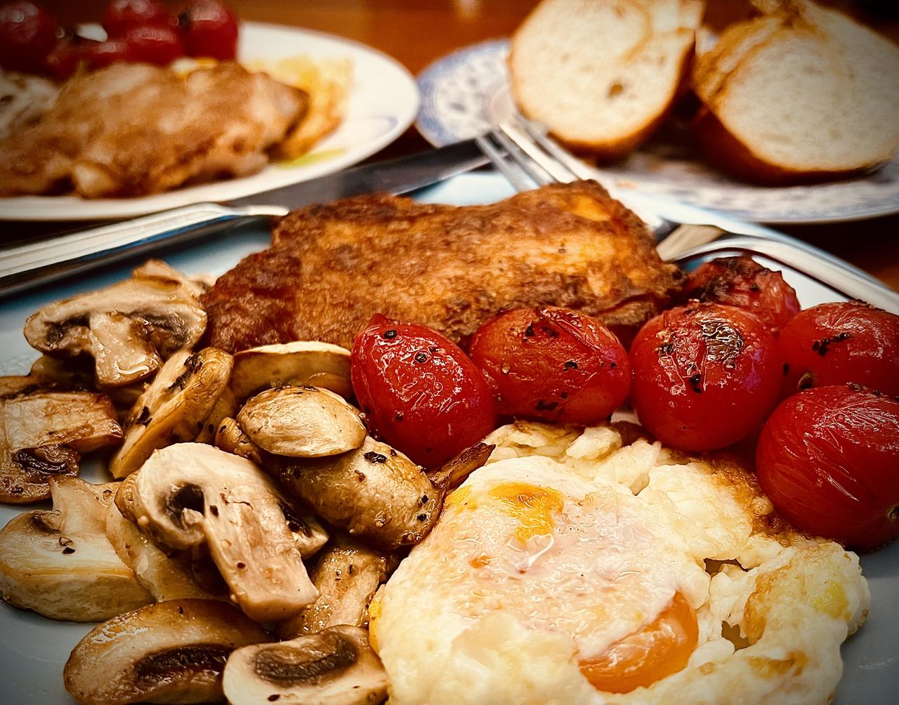 先黄油煎鸡排，再热锅底油煎口蘑和小番茄，撒海盐和胡椒碎，恰到好处就出锅。这时的锅