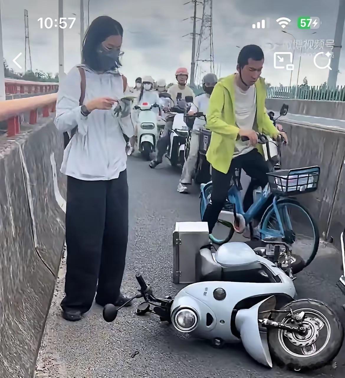 上海早高峰的非机动车道上，一位姑娘车速过快追尾了前车，两人相继倒地。前方男子还好