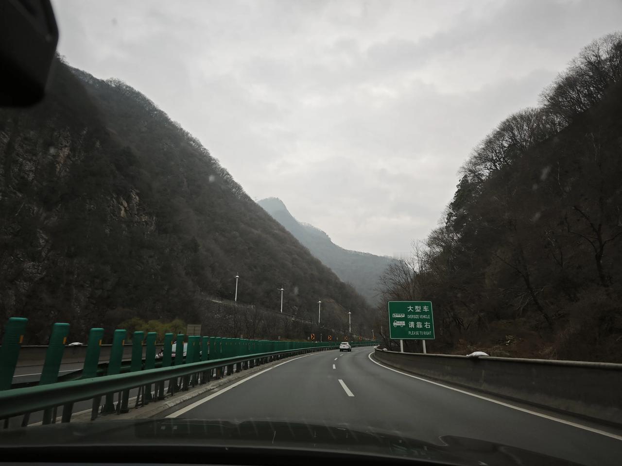 分享一张随手拍穿行在秦岭的群山之间，云雾漫过黛色的山尖，高速路在峡谷里蜿蜒向前。