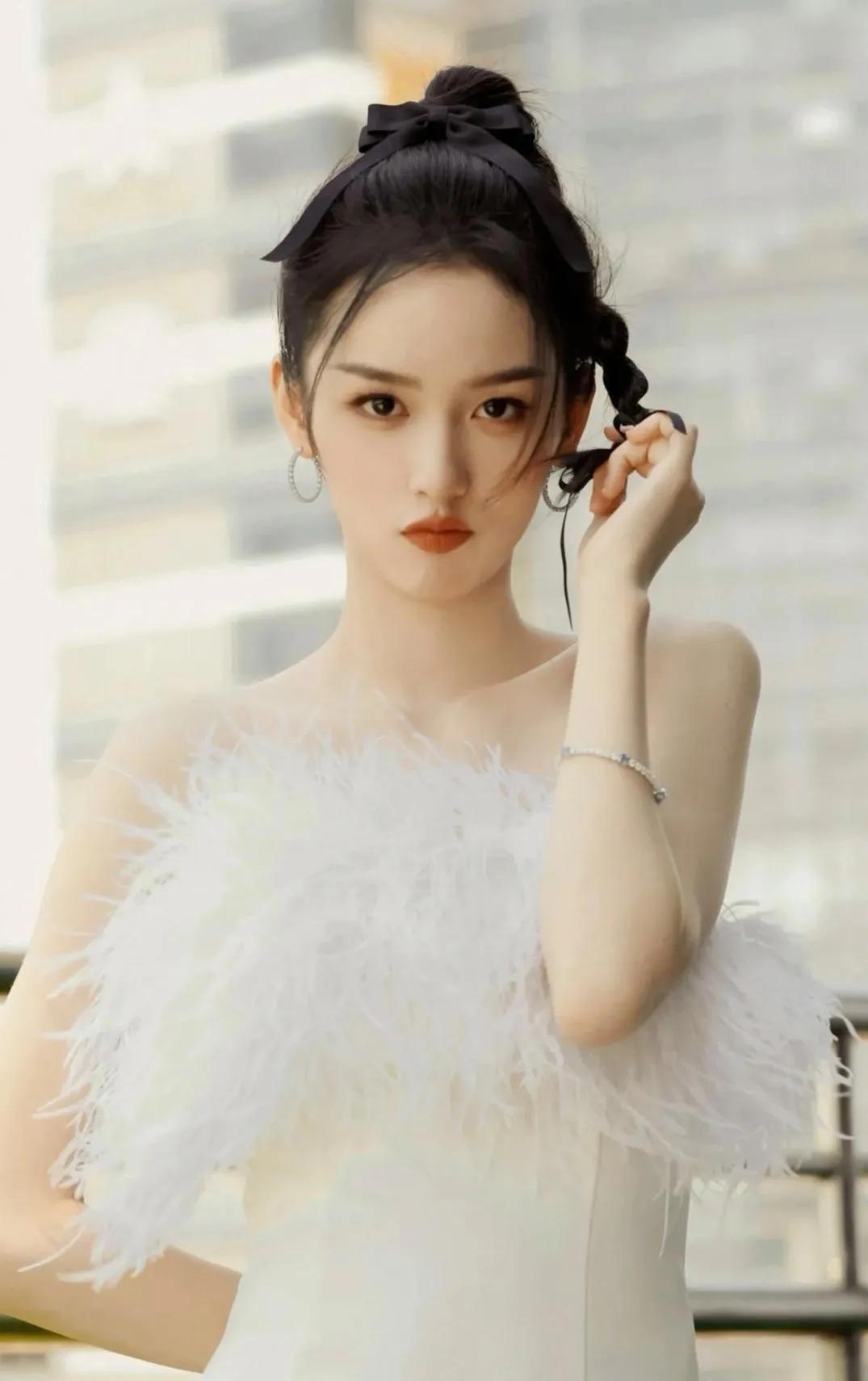 周也身着白色，恰似落入人间的精灵，周身散发着晶莹剔透的气质。她一袭白色连衣裙，如