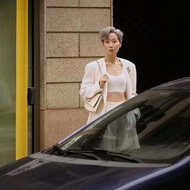 叶童在米兰街头的白发照片，被网友用AI生成的图放在一起比。AI那张脸更光滑，头