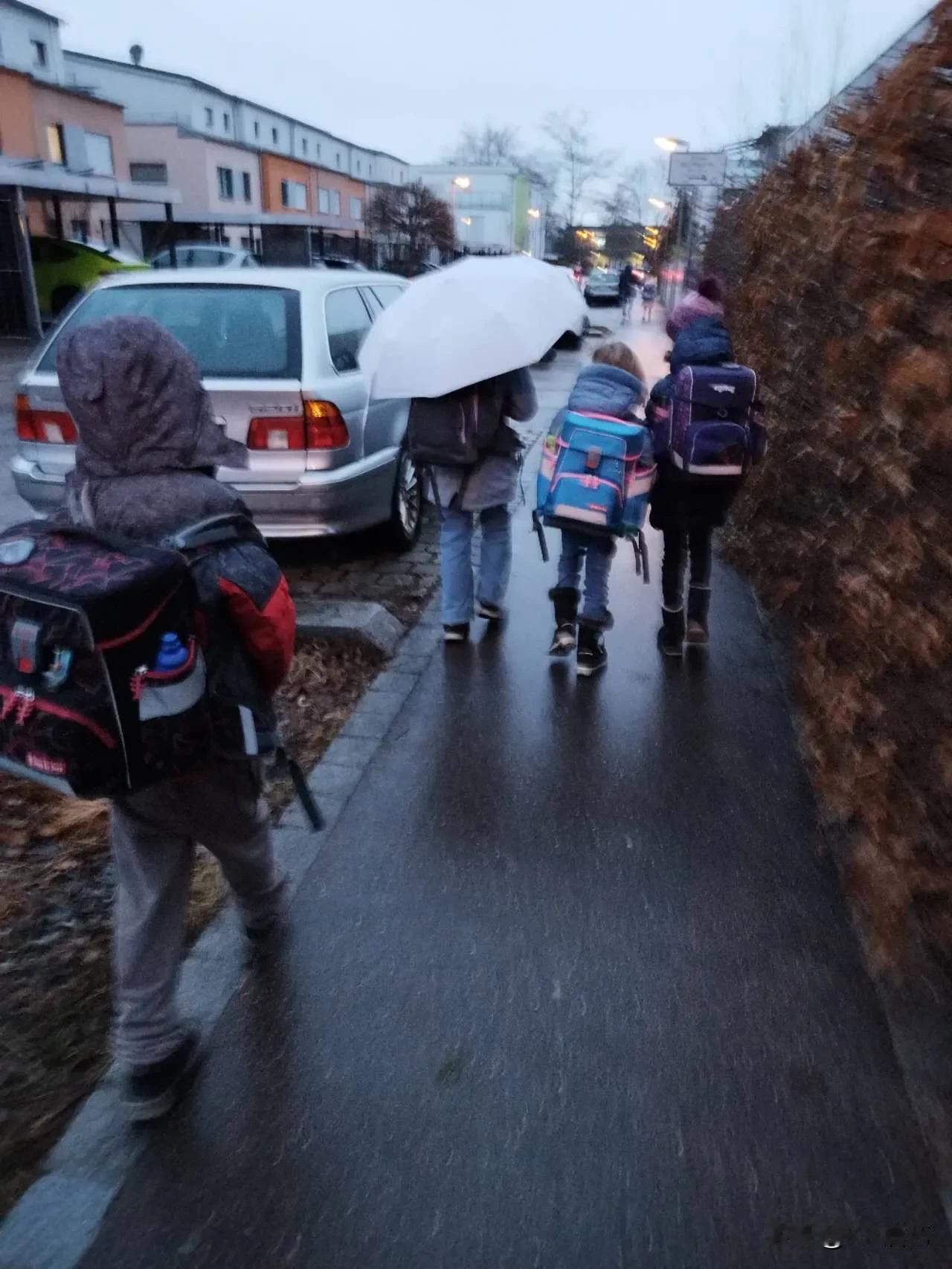 不喜欢打伞的德国人早上下了点小雨。我拿起伞送外孙去学校。