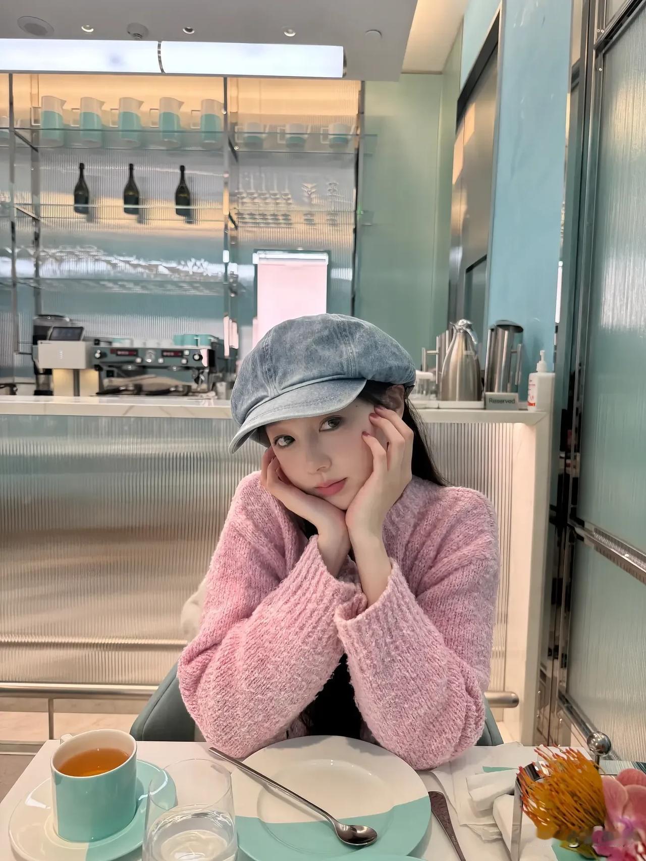 粉衣少女倚窗坐，茶香满溢心自怡。